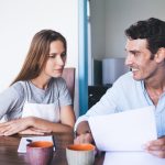 Un couple adulte discute ouvertement du consentement dans une chambre.